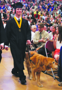 At the Spring 2012 commencement, Mark, guided by his dog Jeter, walks down the center aisle during the processional.