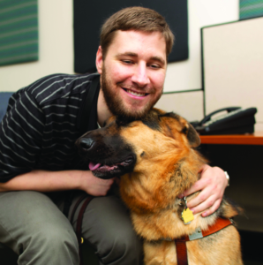 Mark bends down to hug his dog Andy, and Jeter lovingly curls his head into Mark's chest.