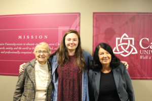 Scholarship recipient takes a photo with two donors