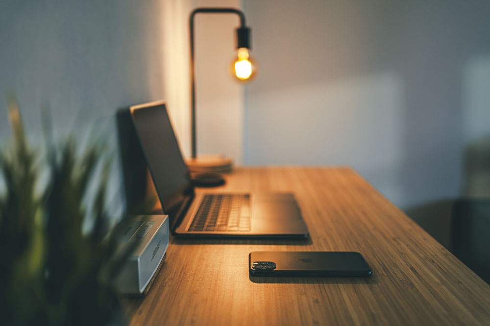 image of a desk witha laptop on it and a lamp glowing behind it